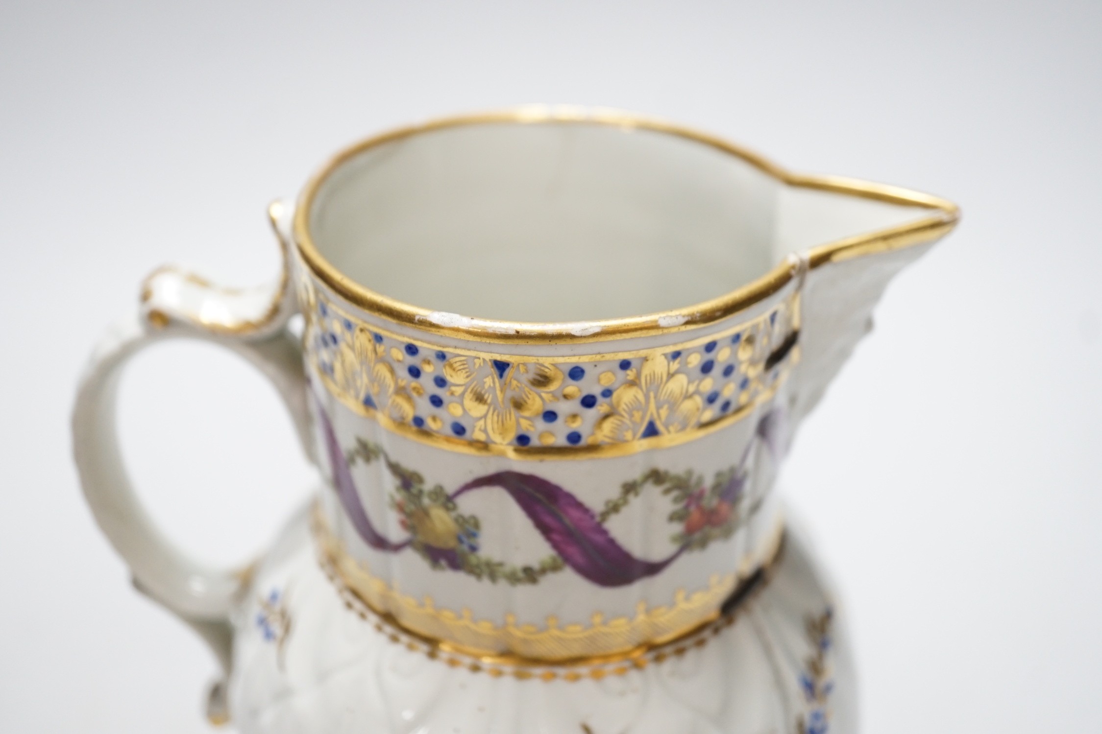 An 18th century Caughley very rare polychrome mask jug, elaboratley painted and gilded with two initials in a dry blue and gilt wreath, Gittins Col., Pictured Caughley Bicentenary Exhibition 1999, with labels, 19cms high